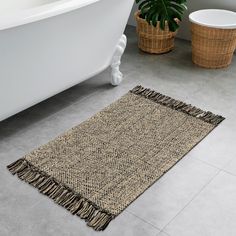 a bath tub sitting next to a rug on the floor