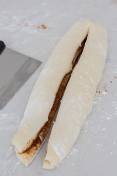 a long piece of bread sitting next to a knife