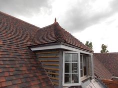 the roof of a house with an orange shingled dormer on it's side