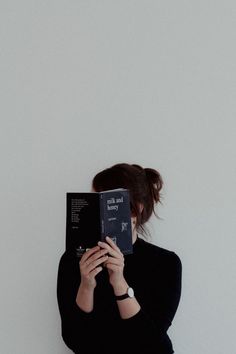 a woman holding a book in front of her face