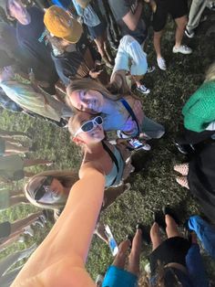 a group of people standing around each other with their hands in the air and looking up