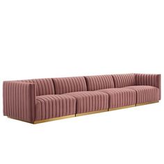 a pink velvet sofa with wooden legs and two rows of pleated fabric on the back