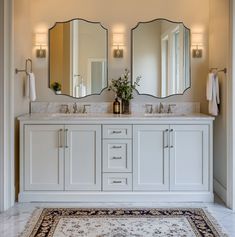 a bathroom with two sinks, mirrors and rug on the floor in front of it