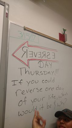 a man standing in front of a whiteboard with writing on it and an arrow pointing to the left