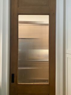 a wooden door with blinds on the glass and sidelight is shown in front of a white wall