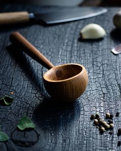 a wooden bowl sitting on top of a table next to some spices and spoons