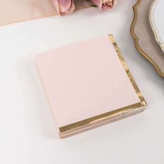 a white table topped with pink flowers next to a mirror and a gold framed frame