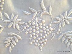 an embroidered piece of cloth with grapes and leaves on it