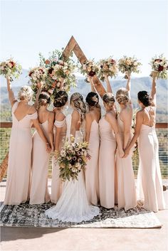 the bridesmaids are holding their bouquets high in the air and posing for a photo