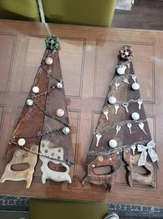 two wooden christmas trees sitting on top of a table