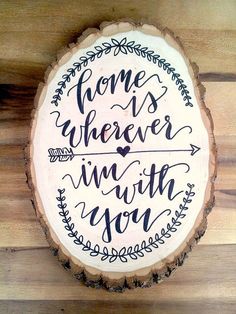 a piece of wood with the words home is wherever in with you written on it