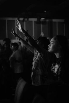 two people standing in front of a crowd holding their hands up