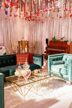 a living room filled with furniture and christmas decorations hanging from the ceiling over a piano