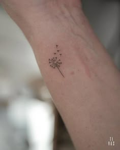 a small dandelion tattoo on the wrist