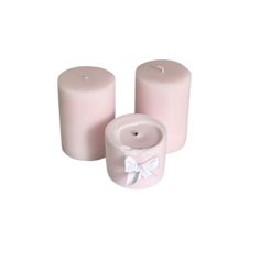 three pink candles with white bows on them