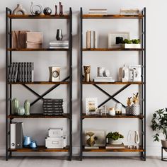 two bookshelves in an empty room with plants and other items on the shelves