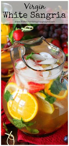 a pitcher filled with fruit and ice sitting on top of a table