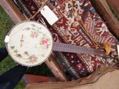 a close up of an instrument on the ground near rugs and other items that have been placed around it