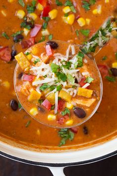 a close up of a bowl of soup with beans, corn and cheese on top