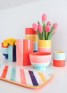 colorful vases and bowls with tulips in them