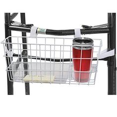 a red cup sitting on top of a metal shelf next to a black and white rack