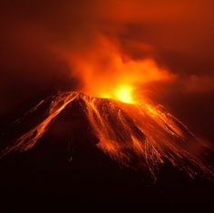 a volcano erupts lava as it rises into the night sky with bright orange lights