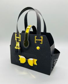 a black and yellow handbag with sunglasses on the handle is sitting in front of a white background