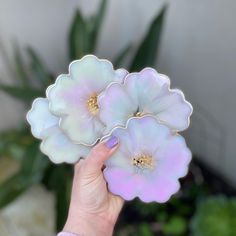 a person holding three flowers in their hand