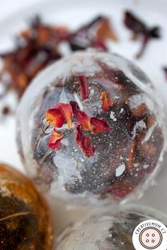 three glass balls with flowers in them sitting on a table