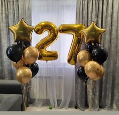 the number twenty two balloons are in front of a curtained window with drapes