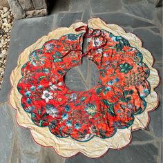 a red and blue flowered wreath on a stone walkway