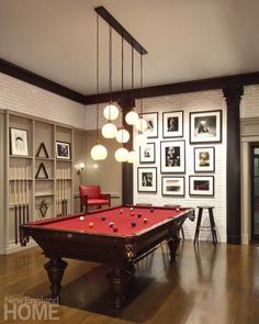 a pool table in a room with pictures on the wall