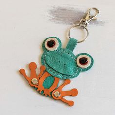 a keychain with an orange and green frog on it