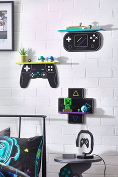 three video game controllers are hanging on the wall above a bed in a room with white brick walls