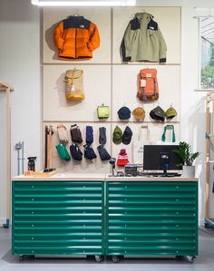 a room with several coats hanging on the wall and two desks in front of them