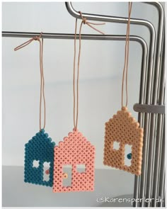 three pieces of perler bead hanging from a rack