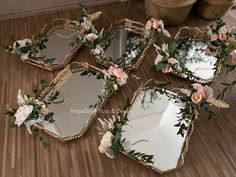 four mirrors with flowers on them sitting on the floor next to a basket and vase