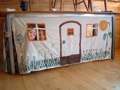 a child's play house made out of cardboard with pictures on the front and sides