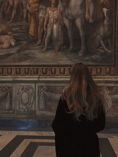 a woman standing in front of a painting