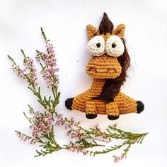 a crocheted stuffed animal sitting on top of a plant next to it's eyes