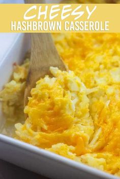 cheesy hashbrown casserole in a white dish with a wooden spoon