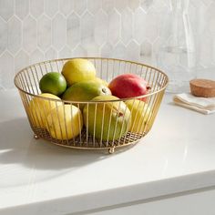 a bowl filled with fruit sitting on top of a counter