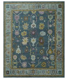 a blue rug with many different colors and designs on the carpet, including an ornate border