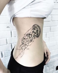 a woman's stomach with a jellyfish tattoo on it