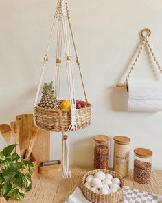 a table topped with baskets filled with fruit and veggies next to kitchen utensils