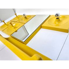 a yellow table with two mirrors on it