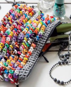 there is a crochet bag with letters on it and beads around the edges