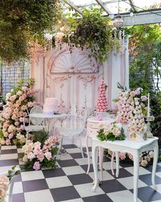 a room filled with tables and chairs covered in pink flowers next to a white wall