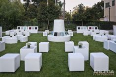 white cubes are arranged on the grass in front of a building