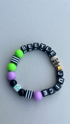 a beaded bracelet with the words believe and police written in black, green, purple, and white beads